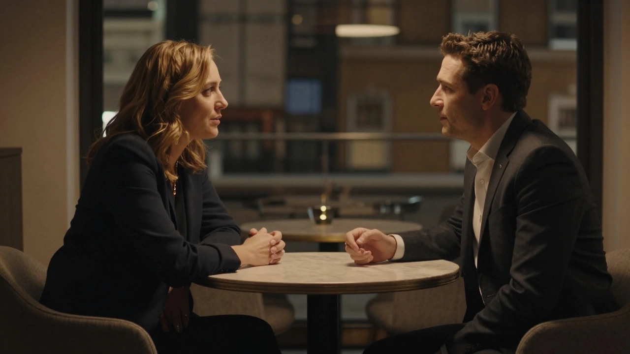 Two people conversing respectfully at a table in a dimly lit room.